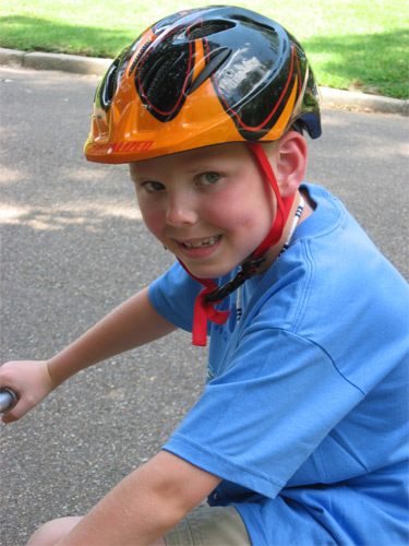 barn med hjälm på cykel